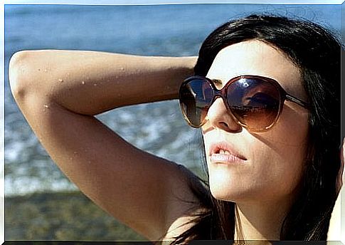 Woman in the sun on the beach with sunglasses