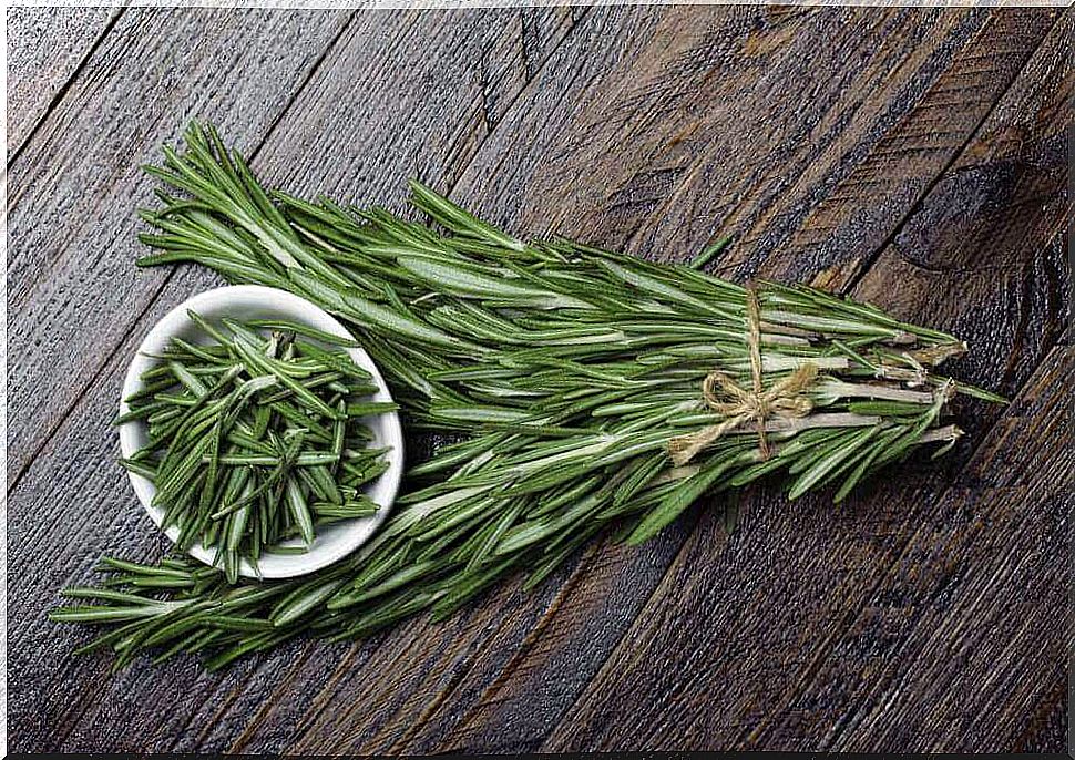 Rosemary and a bowl of rosemary leaves