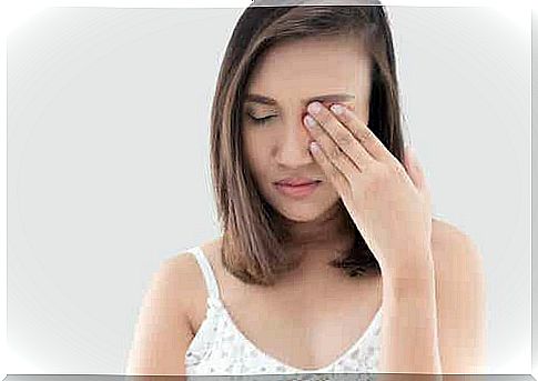 Woman rubs eye