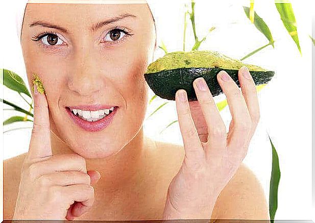 woman puts on mask with avocado