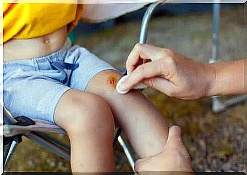 Someone cleans a child's wound